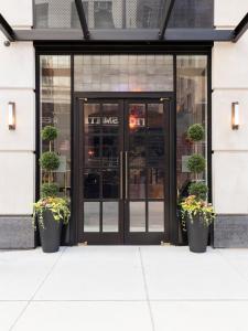 eine Glastür eines Lagers mit Topfpflanzen davor in der Unterkunft Broadway Plaza Hotel in New York