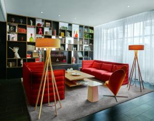 a living room with a red couch and a table at citizenM Amsterdam South in Amsterdam