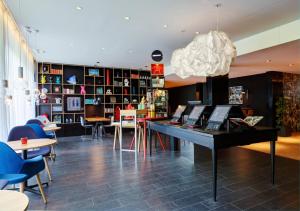 a room with a table and chairs and a library at citizenM Amsterdam South in Amsterdam