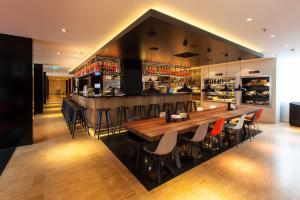 a bar in a restaurant with a wooden table and chairs at citizenM Amsterdam South in Amsterdam