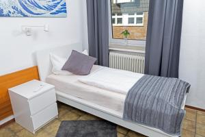 a small bed in a room with a window at Hotel Am Theaterplatz in Bremerhaven