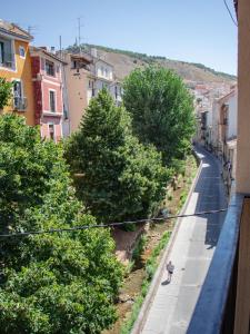 une personne marchant dans une rue à côté d'arbres dans l'établissement Cuencaloft paseo del Huecar, à Cuenca