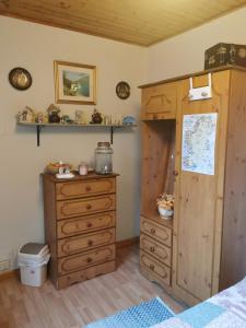 1 dormitorio con armario de madera y vestidor en Catherine's Lair A Quiet peaceful Homestay, en Westport