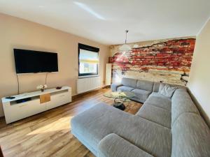 a living room with a couch and a brick wall at Großzügiges Ferienhaus am Senftenberger See mit 2 Terrassen in Senftenberg