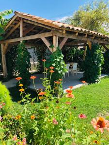 a wooden pergola in a garden with flowers at ,,Anna's" Guesthouse in K'vemo Alvani