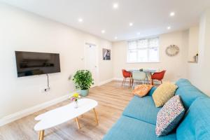 a living room with a blue couch and a table at South Quay Apartment in Great Yarmouth