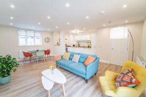 a living room with a blue couch and a table at South Quay Apartment in Great Yarmouth