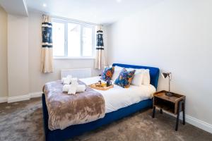 a bedroom with a blue bed with a tray of food on it at South Quay Apartment in Great Yarmouth