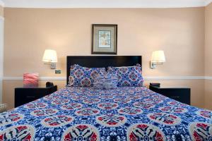 a bedroom with a bed with a blue and red quilt at The BoatHouse in Marco Island