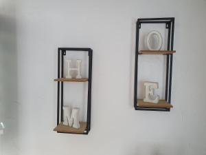 um espelho numa parede com duas prateleiras com vasos em Le Petit Beurre de cacahuète et Le Café de Paris em Fully