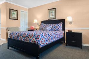 a bedroom with a large bed with a blue comforter at The BoatHouse in Marco Island