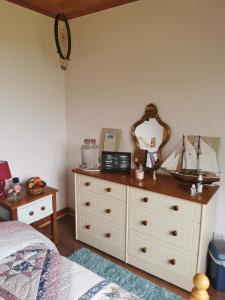a bedroom with a dresser with a ship on it at Catherine's Lair A Quiet peaceful Homestay in Westport