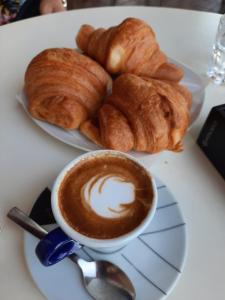 a plate with a cup of coffee and croissants on a table at Villa Angel in Bovalino Marina