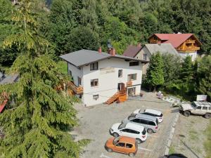 Una vista aérea de una casa con autos estacionados en frente. en Beskidzka Guest House, en Szczyrk