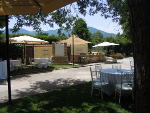 un tavolo con sedie e tavoli e ombrelloni bianchi di Hotel La Campagnola a Rotondi