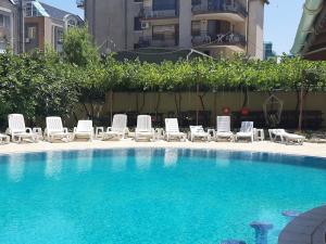 a swimming pool with chairs and a group ofvisorvisorvisor at Apartments Perla Beach - Ivanovi in Primorsko