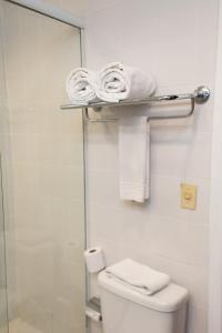 ein Bad mit einer Dusche und einem WC mit Handtüchern in der Unterkunft Master Express Alberto Bins - 200 metros do Hospital Santa Casa in Porto Alegre