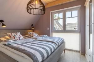 a large bed in a room with a window at EBBEUNFLUT in Sankt Peter-Ording