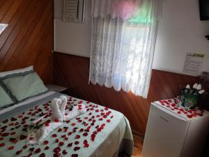 a room with a bed with hearts on it at Pousada Recanto das Águas in Lumiar