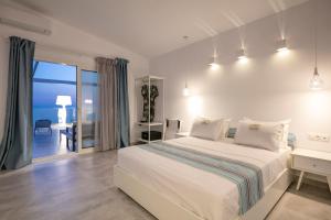 a white bedroom with a bed and a view of the ocean at Mr & Mrs K Bianco in Potos