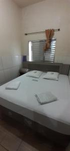 1 cama blanca grande en una habitación con espejo en Hotel Anacleto, en São Paulo