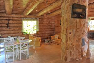 a room with a table and chairs and a stone wall at Dom pod sosnami in Gryżyna