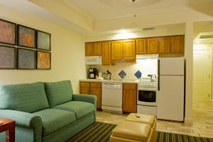 a living room with a couch and a kitchen at Hilton Vacation Club Grand Beach Orlando in Orlando
