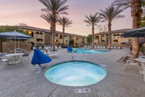 - une piscine avec des tables et des parasols dans un complexe dans l'établissement Holiday Inn Club Vacations Scottsdale Resort, an IHG Hotel, à Scottsdale