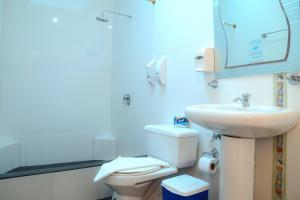 uma casa de banho com um lavatório, um WC e um espelho. em Hostal Sir Francis Drake em Puerto Ayora