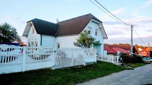 a white house with a white fence at Vila Nela in Podhájska