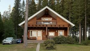 a log cabin with a car parked in front of it at Kotalahden mökki in Kotalahti