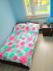 a bed with a polka dot bedsheet and a table at Apartament Puck in Puck