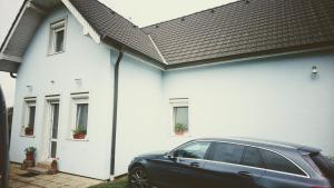 a black car parked in front of a white house at Vila Nela in Podhájska +13 photos