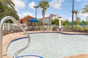 une piscine avec une clôture métallique et un complexe dans l'établissement Hilton Vacation Club Grand Beach Orlando, à Orlando