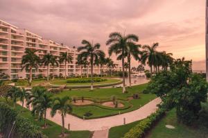 a view of a resort with palm trees and a park at RESTYLE: Ocean front + pool Nuevo Vallarta in Nuevo Vallarta 