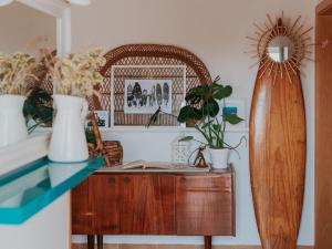 a room with a table with vases and a surfboard at Endless Summer Surf House in Aljezur