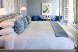 ein großes Bett in einem Zimmer mit blauen Stühlen in der Unterkunft Inns of Aurora Resort & Spa in Aurora