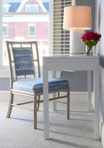 a table and a chair with a table and a vase of flowers at Inns of Aurora Resort & Spa in Aurora