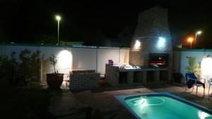 a backyard with a hot tub and a fireplace at night at Welterusten Guesthouse in Strand