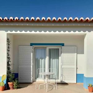 a table and chairs sitting on the porch of a house at Endless Summer Surf House in Aljezur