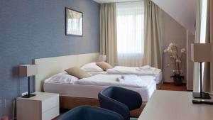 a hotel room with two beds and a chair at Penzion Solid Spa in Mladá Boleslav +100 photos