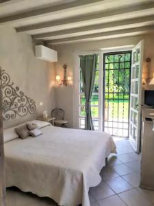 um quarto com uma cama branca e uma porta de vidro deslizante em B&B La Limonaia em Pietrasanta
