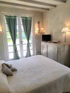 una camera da letto con un grande letto bianco e una finestra di B&B La Limonaia a Pietrasanta