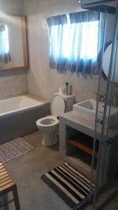 a bathroom with a toilet and a tub and a sink at Abuelita Guesthouse - Room 4 in Lephalale