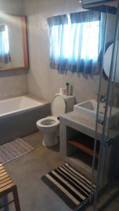 a bathroom with a toilet and a tub and a sink at Homely room in peaceful and comfortable old farmhouse in Lephalale