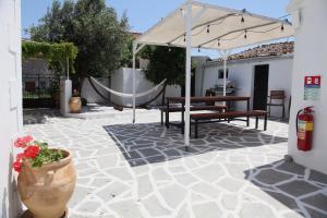 een patio met 2 banken en een parasol bij Keros Apartments in Kalliópi
