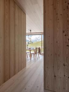 Zimmer mit Holzwänden und einem Esszimmer mit einem Tisch in der Unterkunft Larix Lodge in Stern