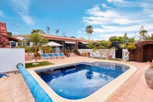 a swimming pool with a large blue pool noodle in a yard at Villas Anais in Callao Salvaje
