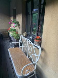 a white bench sitting on a porch next to a window at Kamienica na Krakowskiej 120 m2 in Tarnowskie Góry