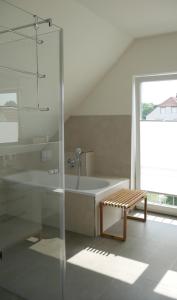 ein Badezimmer mit einer Dusche, einer Badewanne und einer Bank in der Unterkunft Stadtnahe Komfortferienwohnung für Familien und Geschäftsreisende in Hildesheim